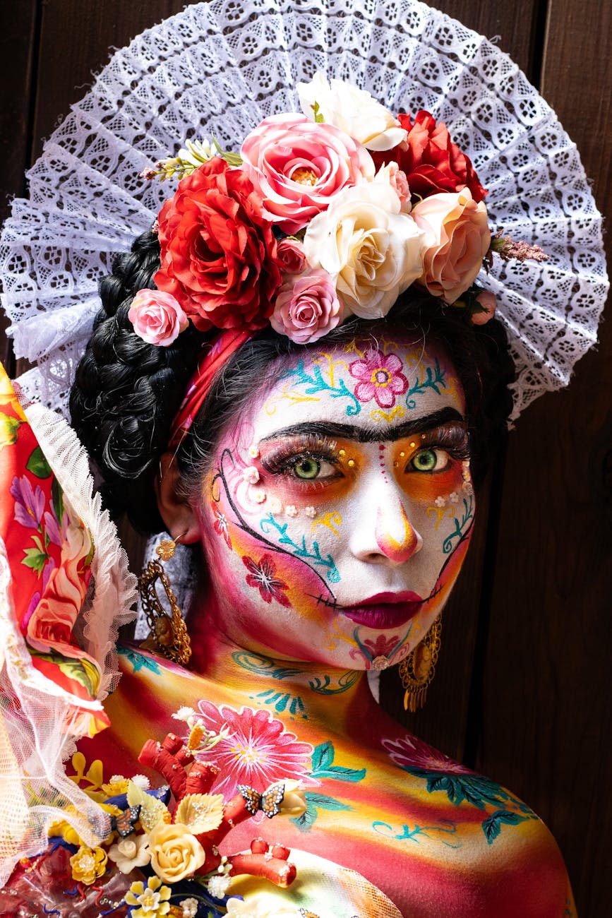 Colorful Day of the Dead makeup with floral headpiece and lace details.